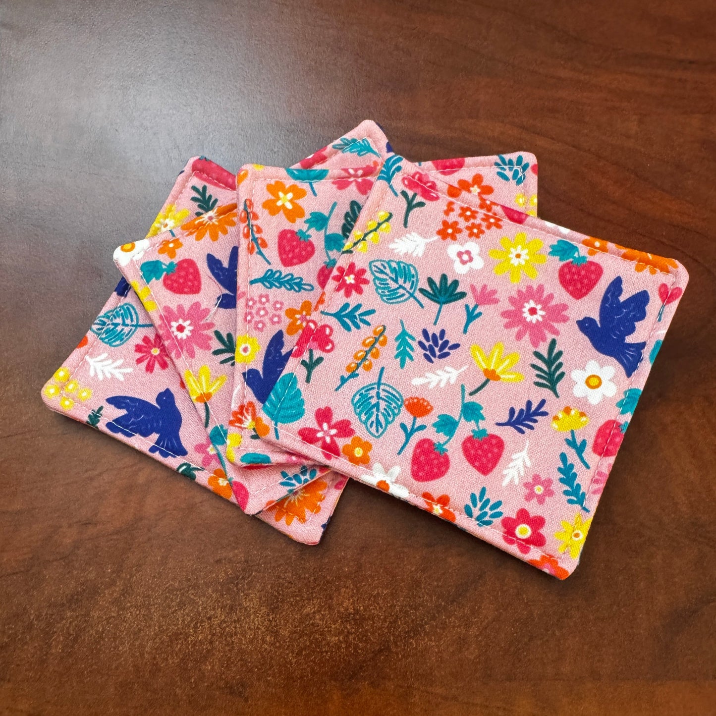 Elevate your space with this playful 100% cotton bird and bloom coaster. Featuring a vibrant and stylish floral and bird print, this coaster brings a touch of whimsical fun to your home. Crafted with an absorbent cotton batting layer inside, it's designed to soak up condensation and protect your furniture from unsightly water rings and spills. Perfect for coffee mugs, glasses, or teacups, this durable and machine-washable coaster is a delightful addition to your kitchen or living room. Elevate your home dec
