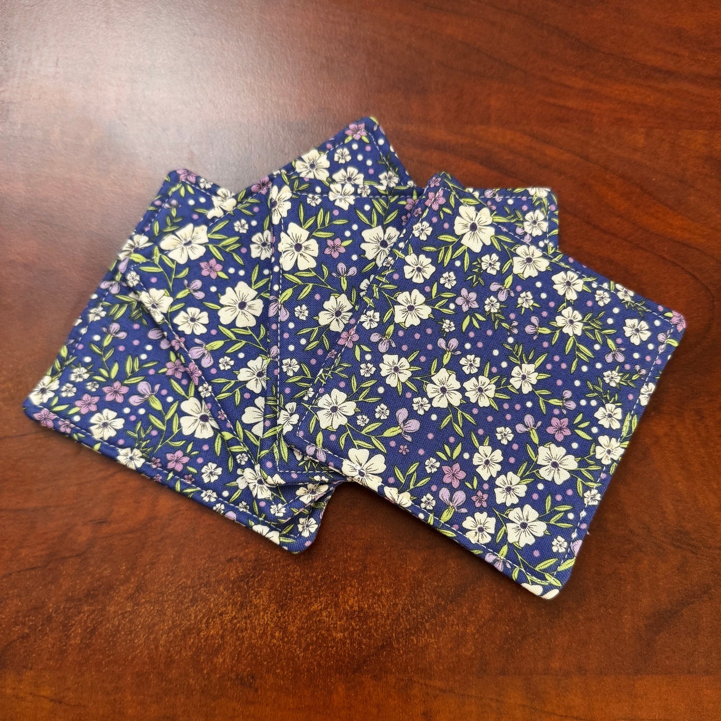 Elevate your space with this playful 100% cotton blue floral coaster. Featuring a vibrant and stylish blue floral print, this coaster brings a touch of floral and fun to your home. Crafted with an absorbent cotton batting layer inside, it's designed to soak up condensation and protect your furniture from unsightly water rings and spills. Perfect for coffee mugs, glasses, or teacups, this durable and machine-washable coaster is a delightful addition to your kitchen or living room. Elevate your home decor wit