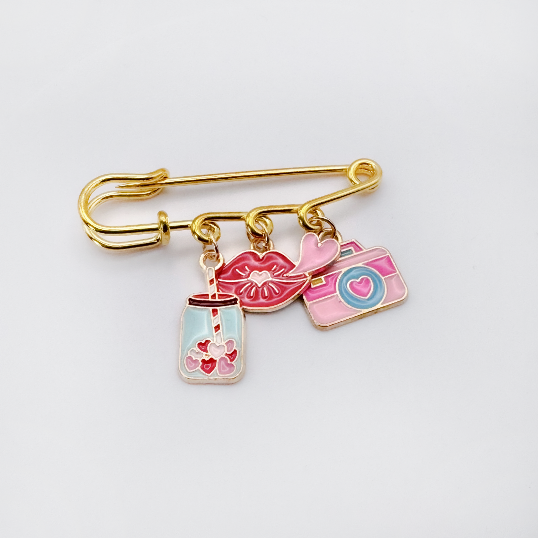 Elevate your Valentines Day or Galentines Day with this adorable gold iron pin brooch featuring coffee and a camera enamel charms. Perfect for adding a touch of love to any outfit.
