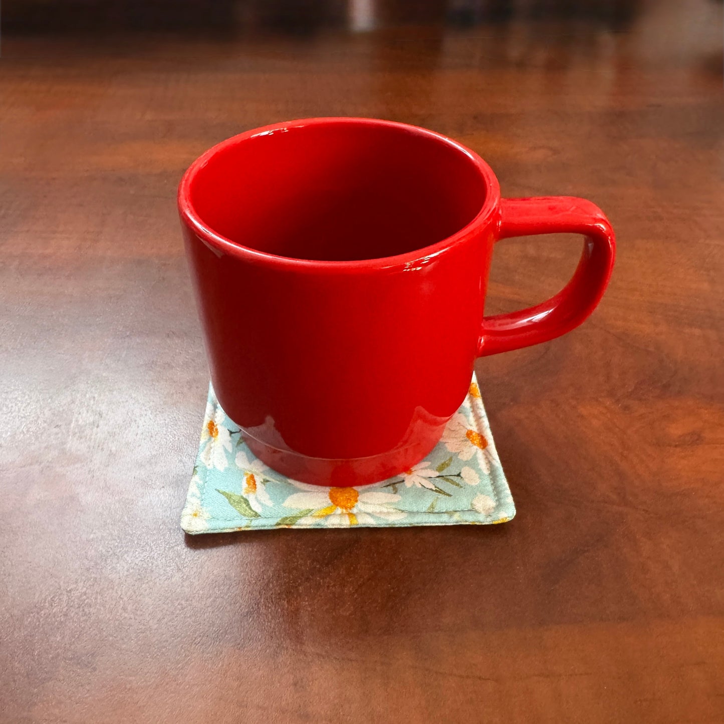 Elevate your space with this playful 100% cotton daisy coaster. Featuring a vibrant and stylish daisy print, this coaster brings a touch of tropical flair and fun to your home. Crafted with an absorbent cotton batting layer inside, it's designed to soak up condensation and protect your furniture from unsightly water rings and spills. Perfect for coffee mugs, glasses, or teacups, this durable and machine-washable coaster is a delightful addition to your kitchen or living room. Elevate your home decor with th
