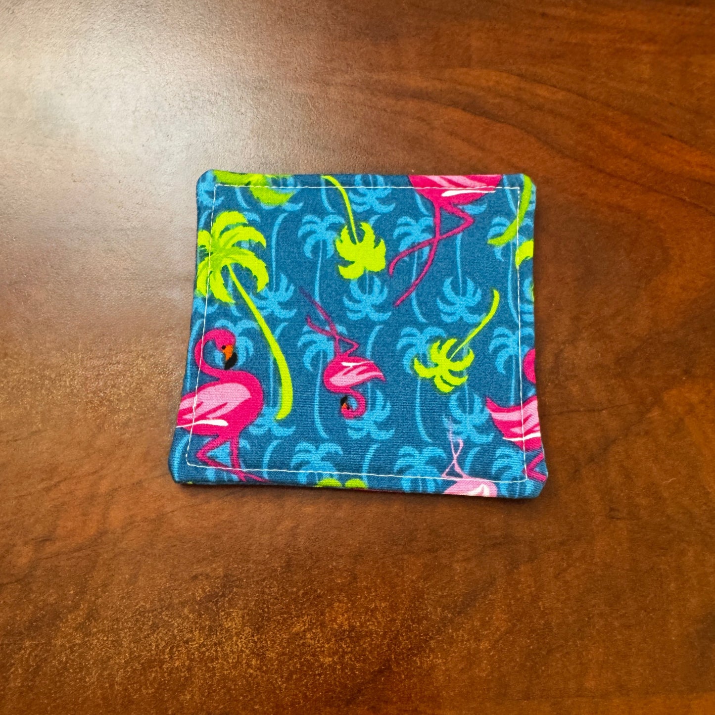 Elevate your space with this playful 100% cotton flamingo coaster. Featuring a vibrant and stylish flamingo print, this coaster brings a touch of tropical flair and fun to your home. Crafted with an absorbent cotton batting layer inside, it's designed to soak up condensation and protect your furniture from unsightly water rings and spills. Perfect for coffee mugs, glasses, or teacups, this durable and machine-washable coaster is a delightful addition to your kitchen or living room. Elevate your home decor w