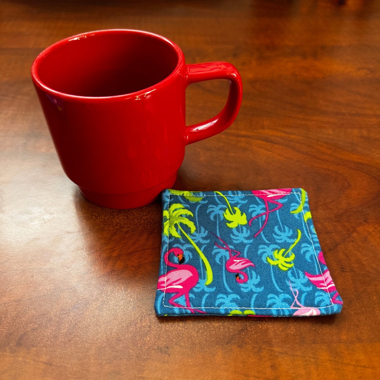Elevate your space with this playful 100% cotton flamingo coaster. Featuring a vibrant and stylish flamingo print, this coaster brings a touch of tropical flair and fun to your home. Crafted with an absorbent cotton batting layer inside, it's designed to soak up condensation and protect your furniture from unsightly water rings and spills. Perfect for coffee mugs, glasses, or teacups, this durable and machine-washable coaster is a delightful addition to your kitchen or living room. Elevate your home decor w