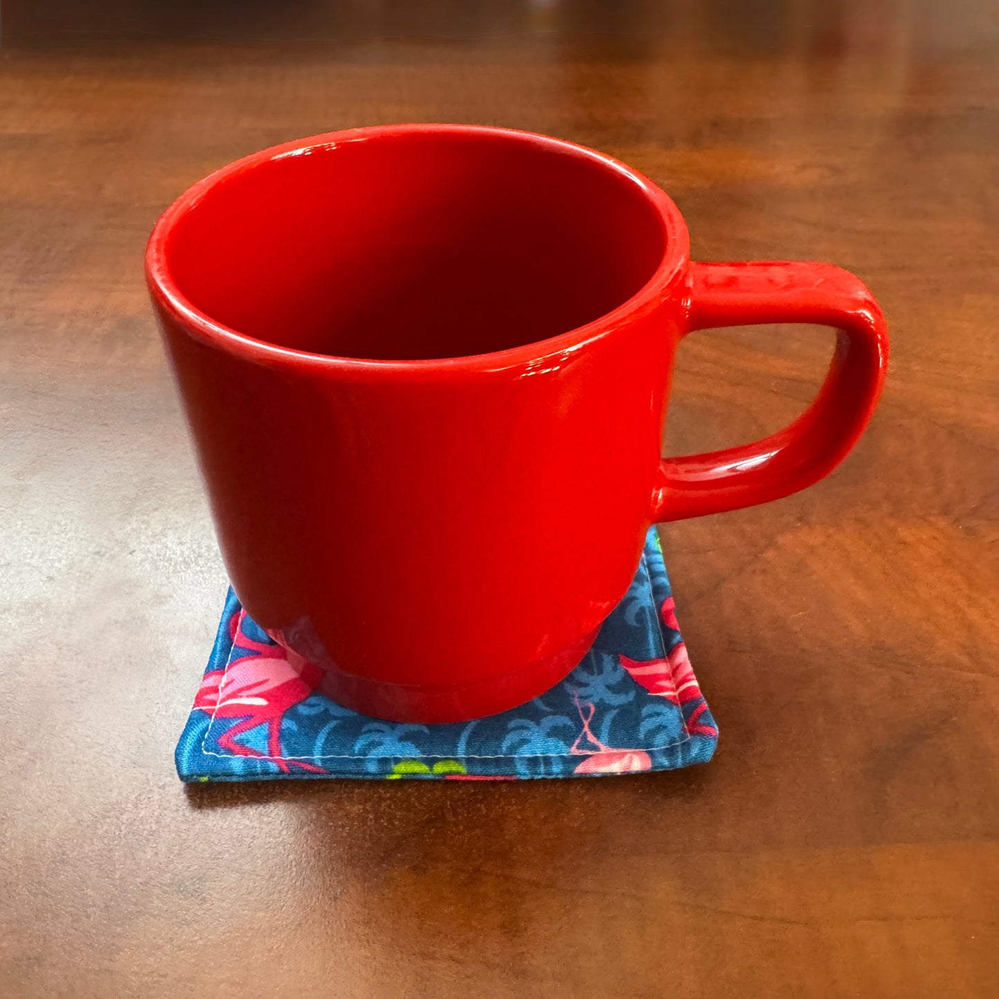 Elevate your space with this playful 100% cotton flamingo coaster. Featuring a vibrant and stylish flamingo print, this coaster brings a touch of tropical flair and fun to your home. Crafted with an absorbent cotton batting layer inside, it's designed to soak up condensation and protect your furniture from unsightly water rings and spills. Perfect for coffee mugs, glasses, or teacups, this durable and machine-washable coaster is a delightful addition to your kitchen or living room. Elevate your home decor w