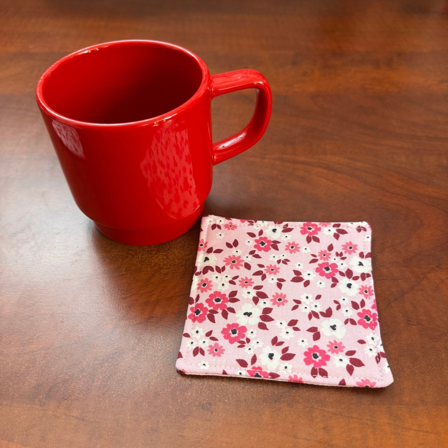 Elevate your space with this playful 100% cotton pink floral coaster. Featuring a vibrant and stylish floral print, this coaster brings a touch of floral and fun to your home. Crafted with an absorbent cotton batting layer inside, it's designed to soak up condensation and protect your furniture from unsightly water rings and spills. Perfect for coffee mugs, glasses, or teacups, this durable and machine-washable coaster is a delightful addition to your kitchen or living room. Elevate your home decor with thi