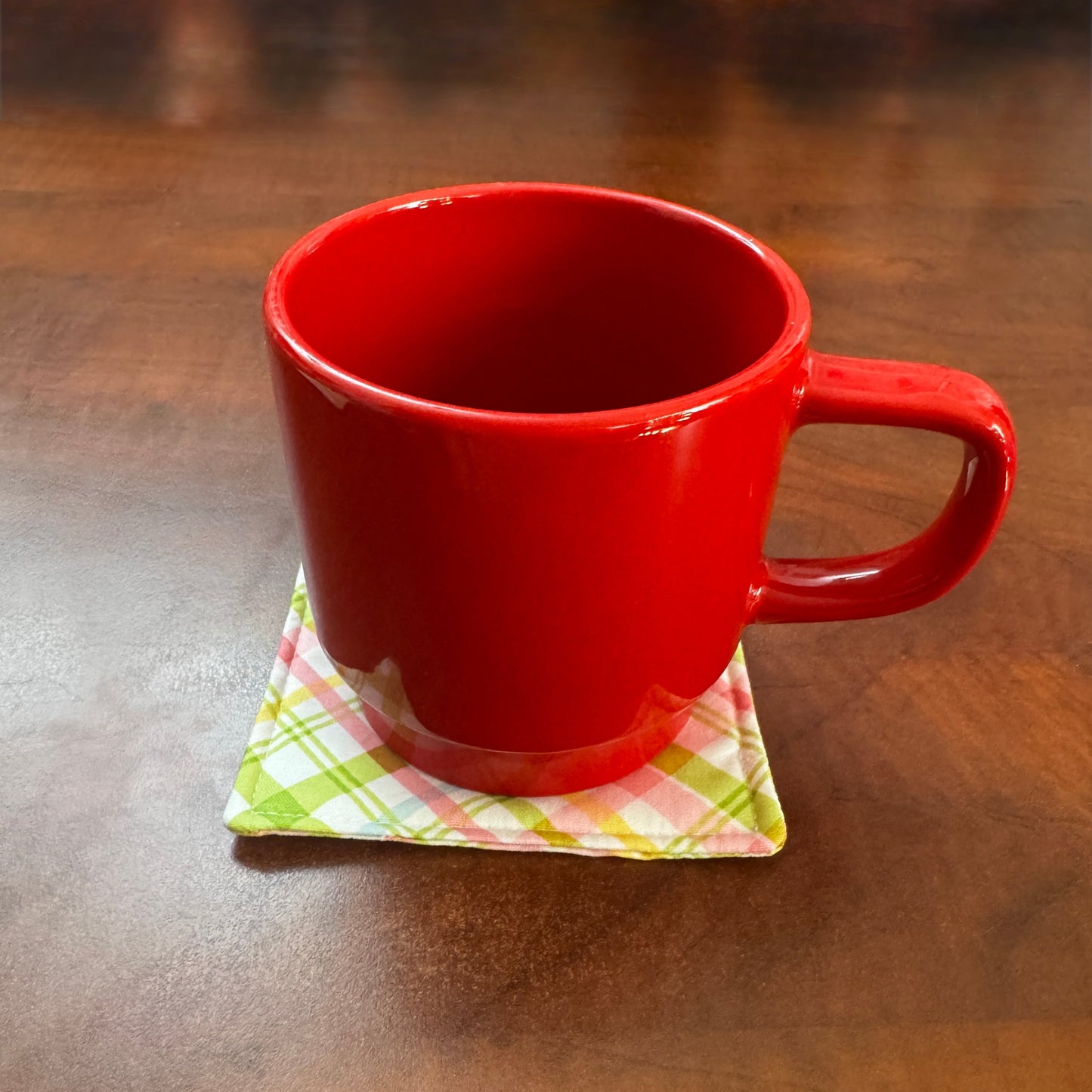 Elevate your space with this playful 100% cotton pink and green plaid coaster. Featuring a vibrant and stylish pink and green plaid print, this coaster brings a touch of retro fun to your home. Crafted with an absorbent cotton batting layer inside, it's designed to soak up condensation and protect your furniture from unsightly water rings and spills. Perfect for coffee mugs, glasses, or teacups, this durable and machine-washable coaster is a delightful addition to your kitchen or living room. Elevate your h