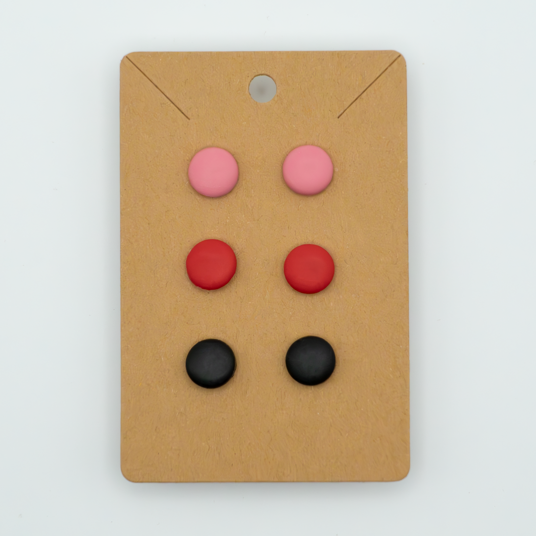 Elevate your everyday look with this stylish pack of three round stud earrings. Featuring the colors pink, red, and black, these versatile earrings are perfect for any occasion.