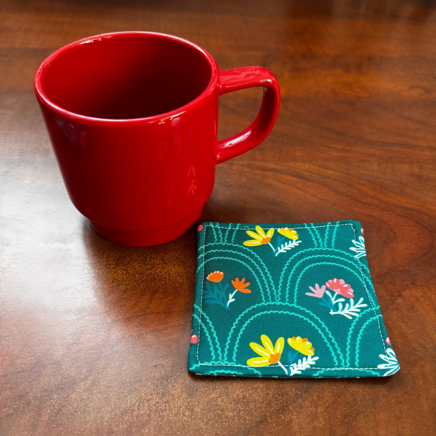 Elevate your space with this playful 100% cotton secret garden coaster. Featuring a vibrant and stylish floral print, this coaster brings a touch of floral and fun to your home. Crafted with an absorbent cotton batting layer inside, it's designed to soak up condensation and protect your furniture from unsightly water rings and spills. Perfect for coffee mugs, glasses, or teacups, this durable and machine-washable coaster is a delightful addition to your kitchen or living room.