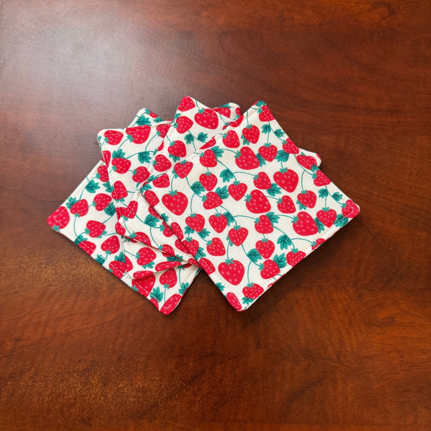 Keep your surfaces safe and stylish with our 100% cotton strawberry coaster. This charming coaster features a vibrant strawberry print that adds a touch of fresh, fruity fun to any room. Crafted with an absorbent cotton batting layer inside, it's designed to soak up condensation and protect your furniture from unsightly water rings and spills. Perfect for coffee mugs, glasses, or teacups, this durable and machine-washable coaster is a delightful addition to your kitchen or living room. Elevate your home dec