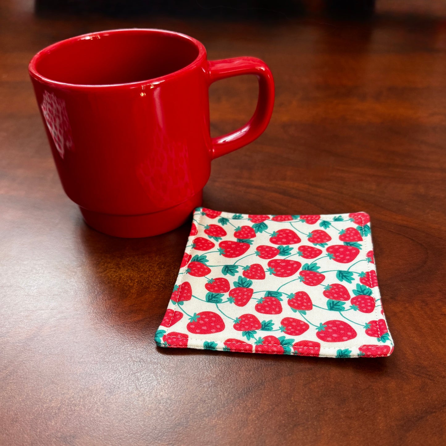 Keep your surfaces safe and stylish with our 100% cotton strawberry coaster. This charming coaster features a vibrant strawberry print that adds a touch of fresh, fruity fun to any room. Crafted with an absorbent cotton batting layer inside, it's designed to soak up condensation and protect your furniture from unsightly water rings and spills. Perfect for coffee mugs, glasses, or teacups, this durable and machine-washable coaster is a delightful addition to your kitchen or living room. Elevate your home dec