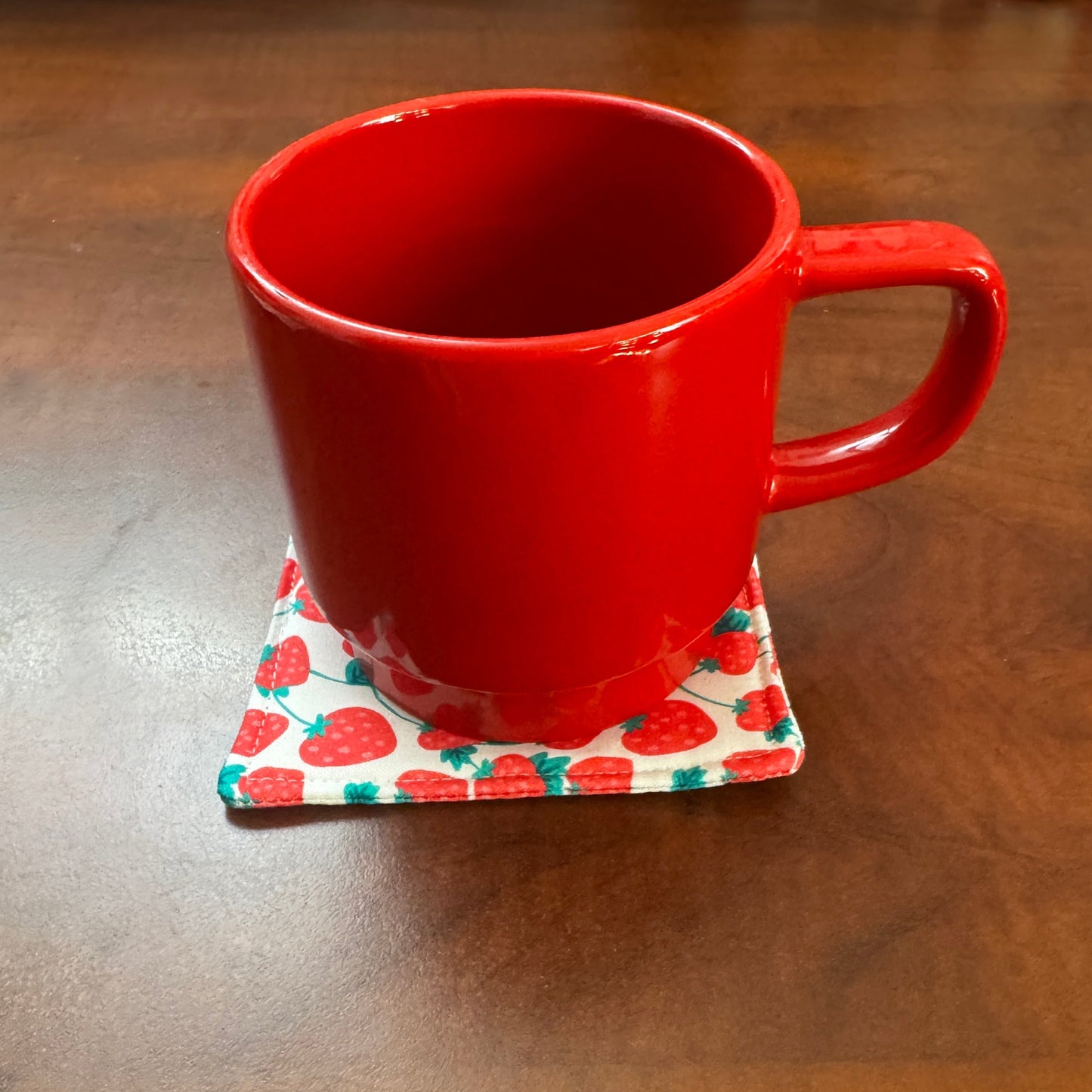 Keep your surfaces safe and stylish with our 100% cotton strawberry coaster. This charming coaster features a vibrant strawberry print that adds a touch of fresh, fruity fun to any room. Crafted with an absorbent cotton batting layer inside, it's designed to soak up condensation and protect your furniture from unsightly water rings and spills. Perfect for coffee mugs, glasses, or teacups, this durable and machine-washable coaster is a delightful addition to your kitchen or living room. Elevate your home dec