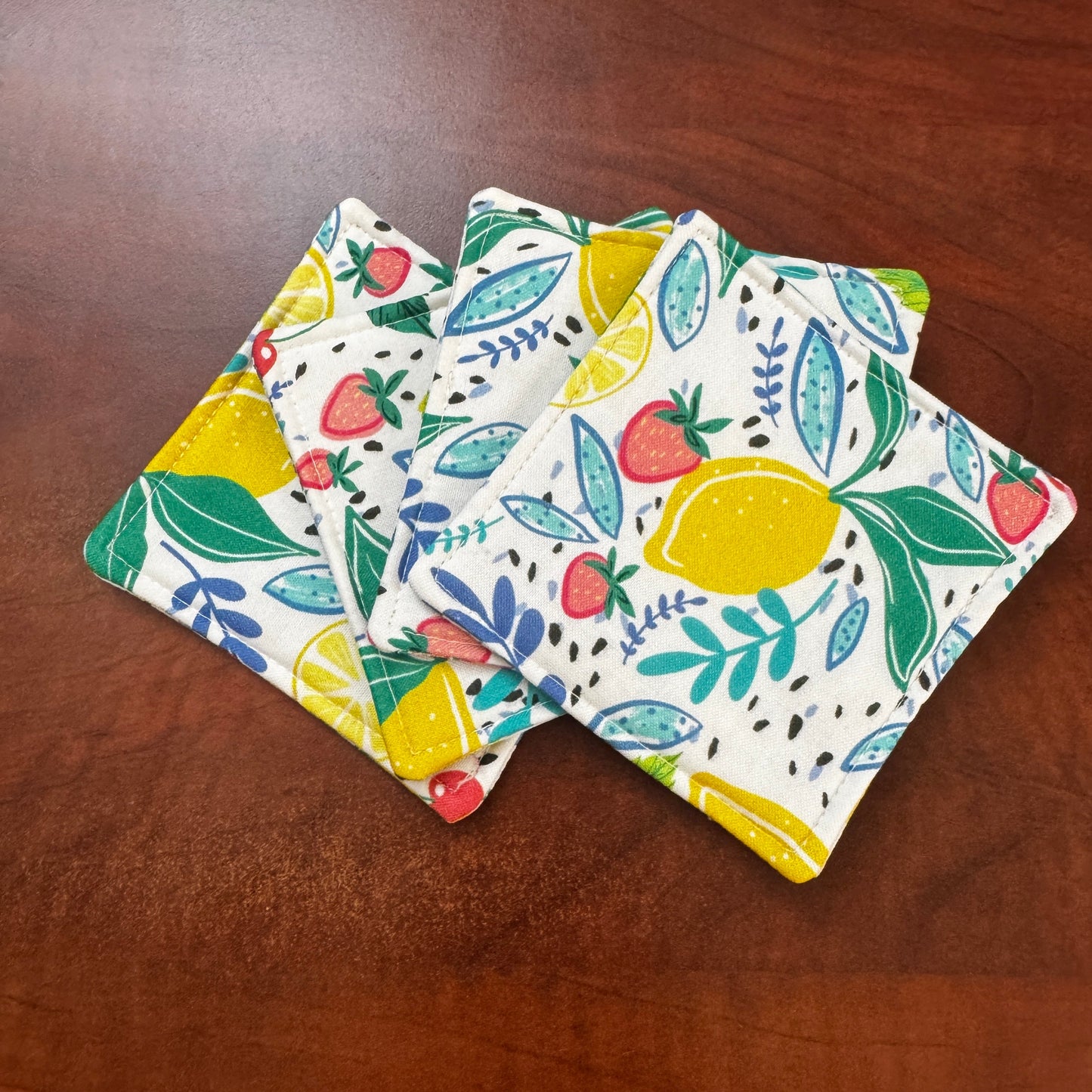 Keep your surfaces safe and stylish with our 100% cotton strawberry and lemon coaster. This charming coaster features a vibrant strawberry and lemon print that adds a touch of fresh, fruity fun to any room. Crafted with an absorbent cotton batting layer inside, it's designed to soak up condensation and protect your furniture from unsightly water rings and spills. Perfect for coffee mugs, glasses, or teacups, this durable and machine-washable coaster is a delightful addition to your kitchen or living room. E
