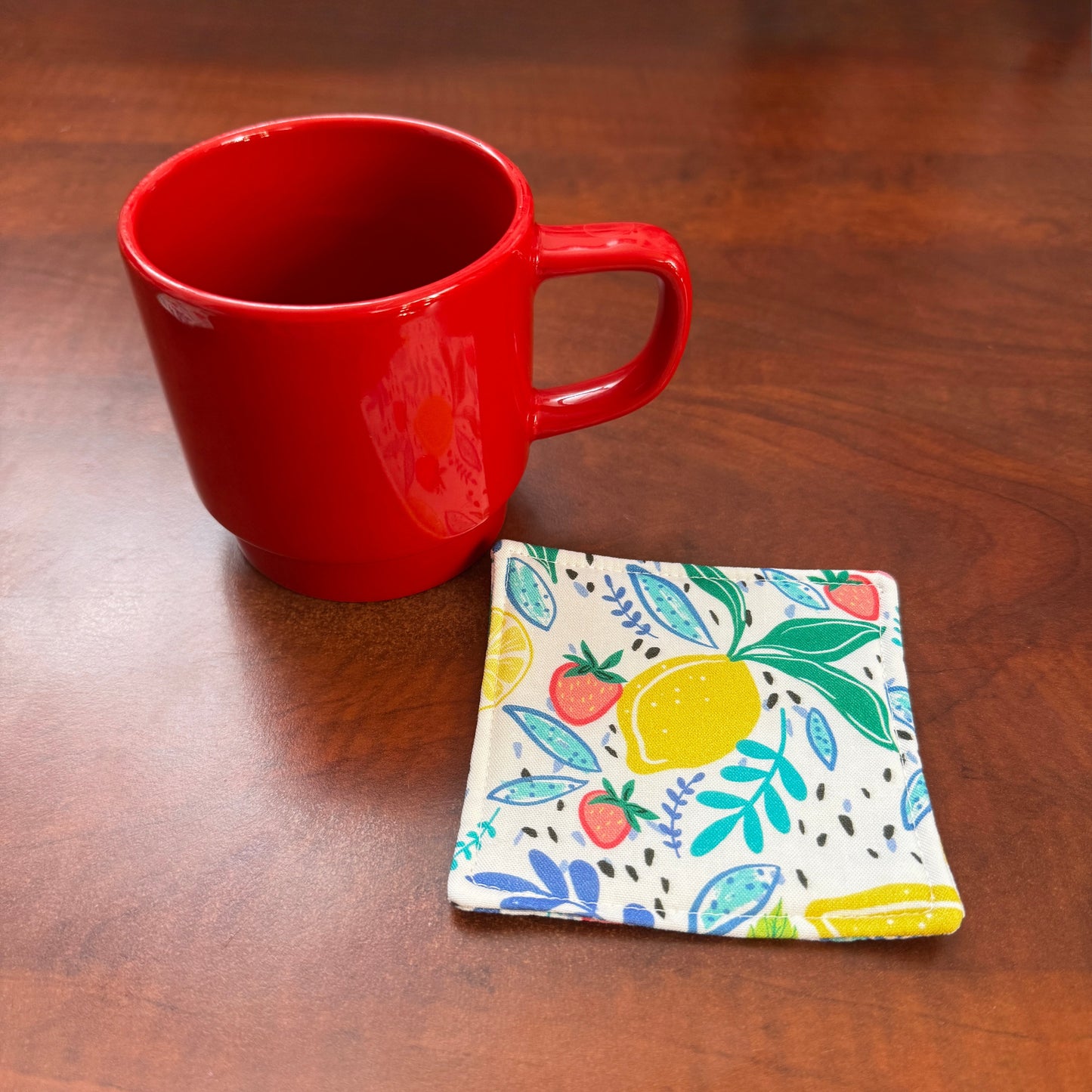 Keep your surfaces safe and stylish with our 100% cotton strawberry and lemon coaster. This charming coaster features a vibrant strawberry and lemon print that adds a touch of fresh, fruity fun to any room. Crafted with an absorbent cotton batting layer inside, it's designed to soak up condensation and protect your furniture from unsightly water rings and spills. Perfect for coffee mugs, glasses, or teacups, this durable and machine-washable coaster is a delightful addition to your kitchen or living room. E