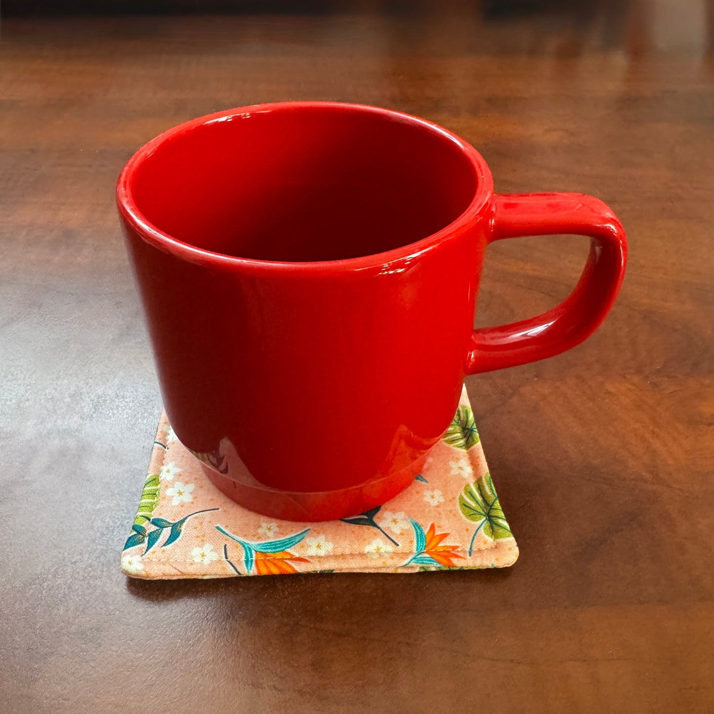 Elevate your space with this playful 100% cotton tropical coaster. Featuring a vibrant and stylish tropical print, this coaster brings a touch of tropical flair and fun to your home. Crafted with an absorbent cotton batting layer inside, it's designed to soak up condensation and protect your furniture from unsightly water rings and spills. Perfect for coffee mugs, glasses, or teacups, this durable and machine-washable coaster is a delightful addition to your kitchen or living room. Elevate your home decor w