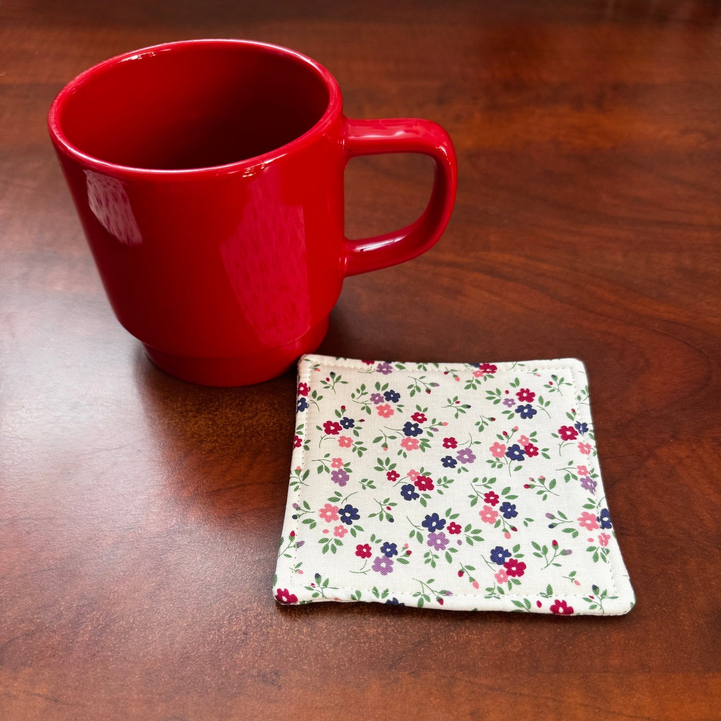 Elevate your space with this playful 100% cotton white floral coaster. Featuring a vibrant and stylish floral print, this coaster brings a touch of floral and fun to your home. Crafted with an absorbent cotton batting layer inside, it's designed to soak up condensation and protect your furniture from unsightly water rings and spills. Perfect for coffee mugs, glasses, or teacups, this durable and machine-washable coaster is a delightful addition to your kitchen or living room. Elevate your home decor with th