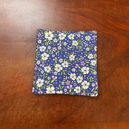 Elevate your space with this playful 100% cotton blue floral coaster. Featuring a vibrant and stylish blue floral print, this coaster brings a touch of floral and fun to your home. Crafted with an absorbent cotton batting layer inside, it's designed to soak up condensation and protect your furniture from unsightly water rings and spills. Perfect for coffee mugs, glasses, or teacups, this durable and machine-washable coaster is a delightful addition to your kitchen or living room. Elevate your home decor wit