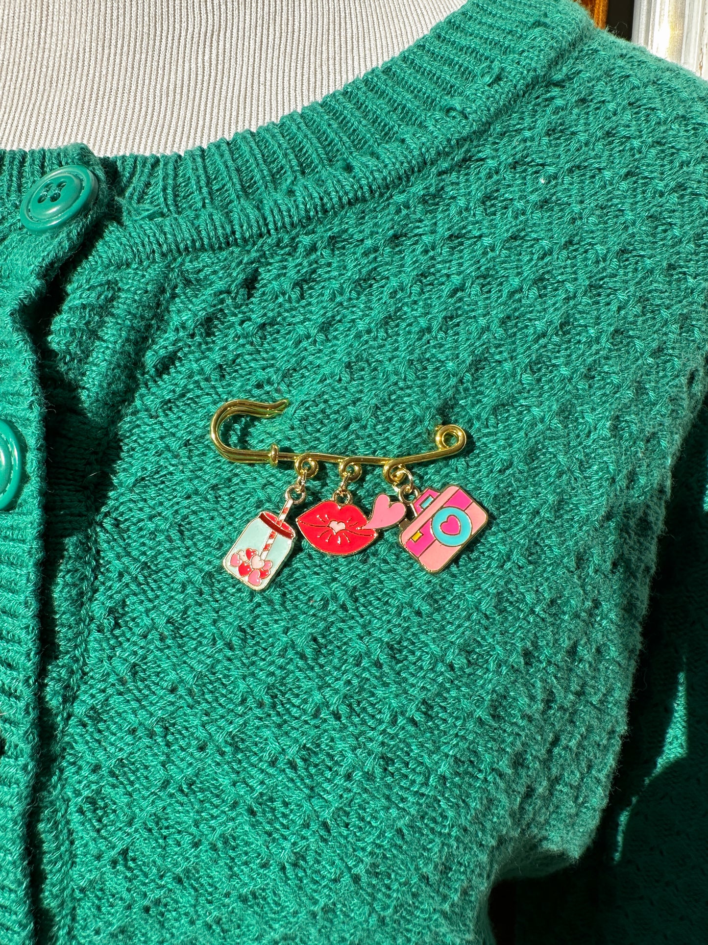 Elevate your Valentines Day or Galentines Day with this adorable gold iron pin brooch featuring coffee, lips, and a camera enamel charms. Perfect for adding a touch of love to any outfit.