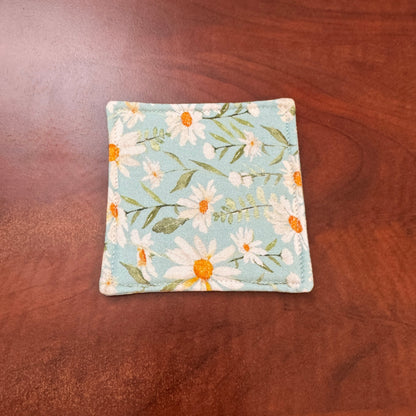 Elevate your space with this playful 100% cotton daisy coaster. Featuring a vibrant and stylish daisy print, this coaster brings a touch of tropical flair and fun to your home. Crafted with an absorbent cotton batting layer inside, it's designed to soak up condensation and protect your furniture from unsightly water rings and spills. Perfect for coffee mugs, glasses, or teacups, this durable and machine-washable coaster is a delightful addition to your kitchen or living room. Elevate your home decor with th