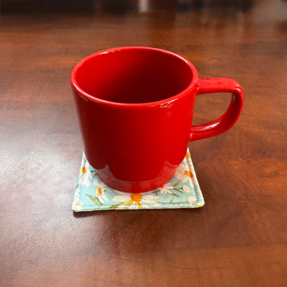 Elevate your space with this playful 100% cotton daisy coaster. Featuring a vibrant and stylish daisy print, this coaster brings a touch of tropical flair and fun to your home. Crafted with an absorbent cotton batting layer inside, it's designed to soak up condensation and protect your furniture from unsightly water rings and spills. Perfect for coffee mugs, glasses, or teacups, this durable and machine-washable coaster is a delightful addition to your kitchen or living room. Elevate your home decor with th