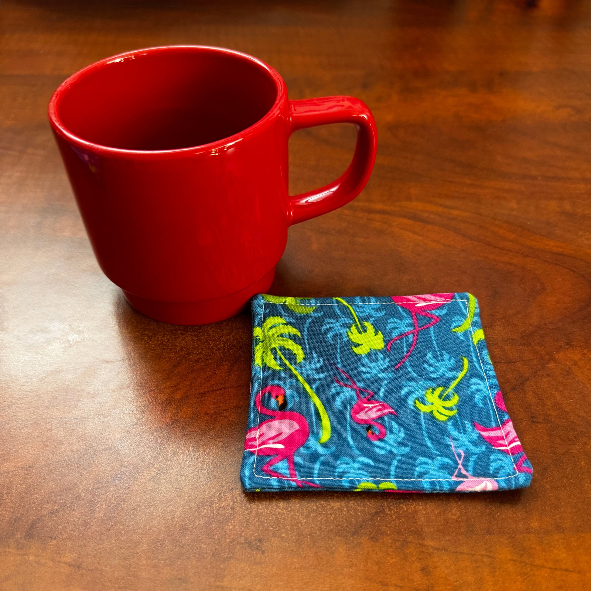 Elevate your space with this playful 100% cotton flamingo coaster. Featuring a vibrant and stylish flamingo print, this coaster brings a touch of tropical flair and fun to your home. Crafted with an absorbent cotton batting layer inside, it's designed to soak up condensation and protect your furniture from unsightly water rings and spills. Perfect for coffee mugs, glasses, or teacups, this durable and machine-washable coaster is a delightful addition to your kitchen or living room. Elevate your home decor w