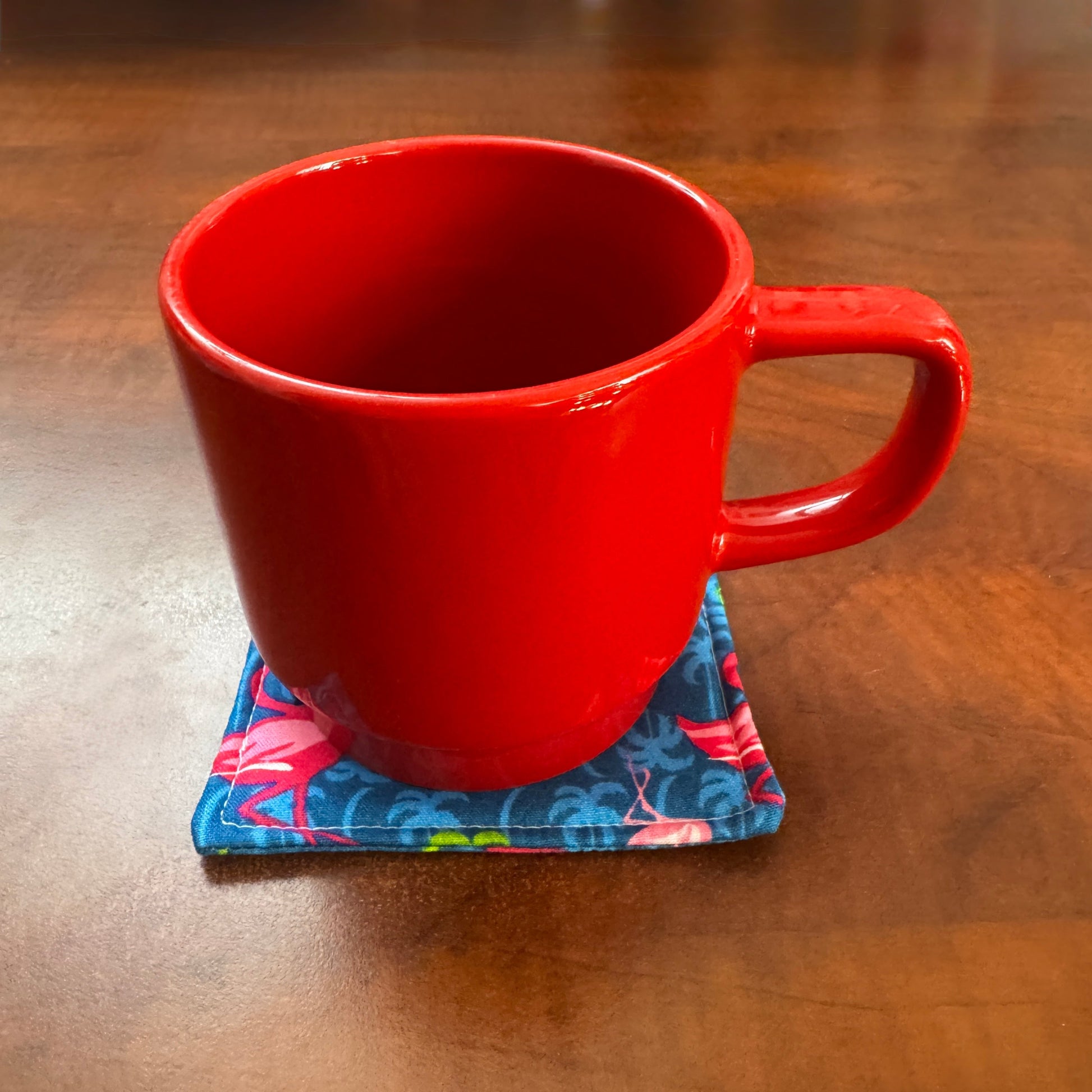 Elevate your space with this playful 100% cotton flamingo coaster. Featuring a vibrant and stylish flamingo print, this coaster brings a touch of tropical flair and fun to your home. Crafted with an absorbent cotton batting layer inside, it's designed to soak up condensation and protect your furniture from unsightly water rings and spills. Perfect for coffee mugs, glasses, or teacups, this durable and machine-washable coaster is a delightful addition to your kitchen or living room. Elevate your home decor w
