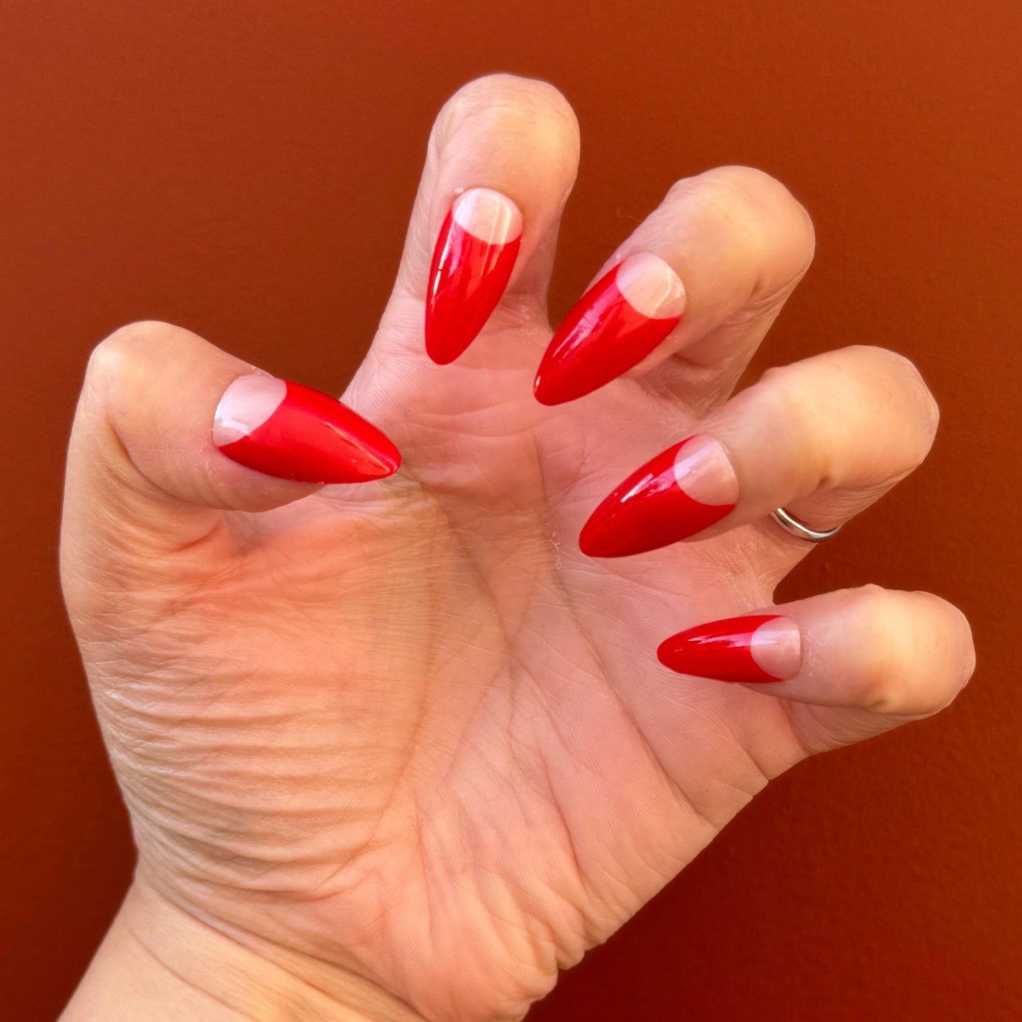 Get ready for "The Red Half Moon" and embrace dark glamour with these stunning handmade press-on nails, featuring a nude base and delicate, red half moon design.