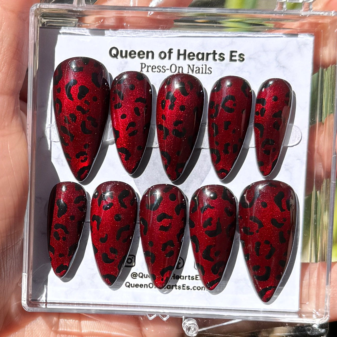 Get ready for "The Fierce Feline" and embrace dark glamour with these stunning handmade press-on nails, featuring a red cat eye base and delicate, black leopard design.&nbsp;