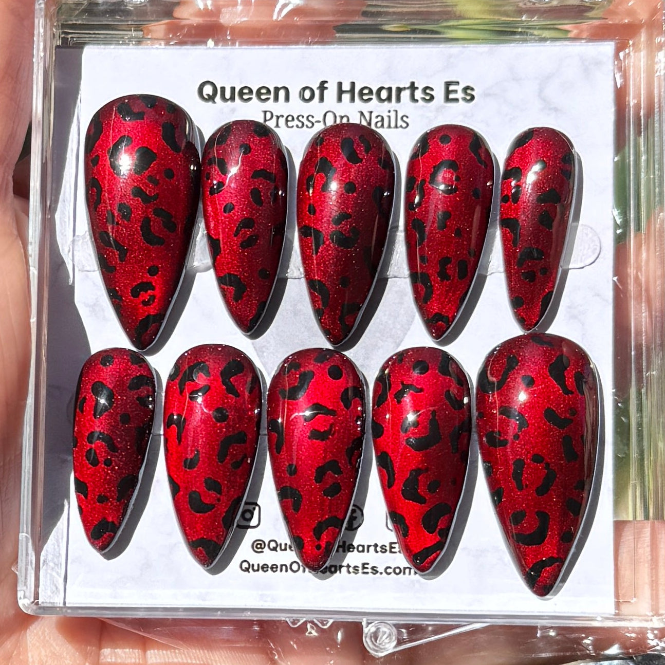 Get ready for "The Fierce Feline" and embrace dark glamour with these stunning handmade press-on nails, featuring a red cat eye base and delicate, black leopard design.&nbsp;