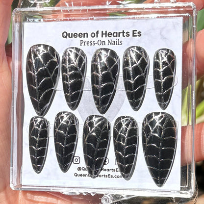 Get ready for "The Silver Weaver" and embrace dark glamour with these stunning handmade press-on nails, featuring a black base and delicate, silver/chrome spiderweb design.&nbsp;