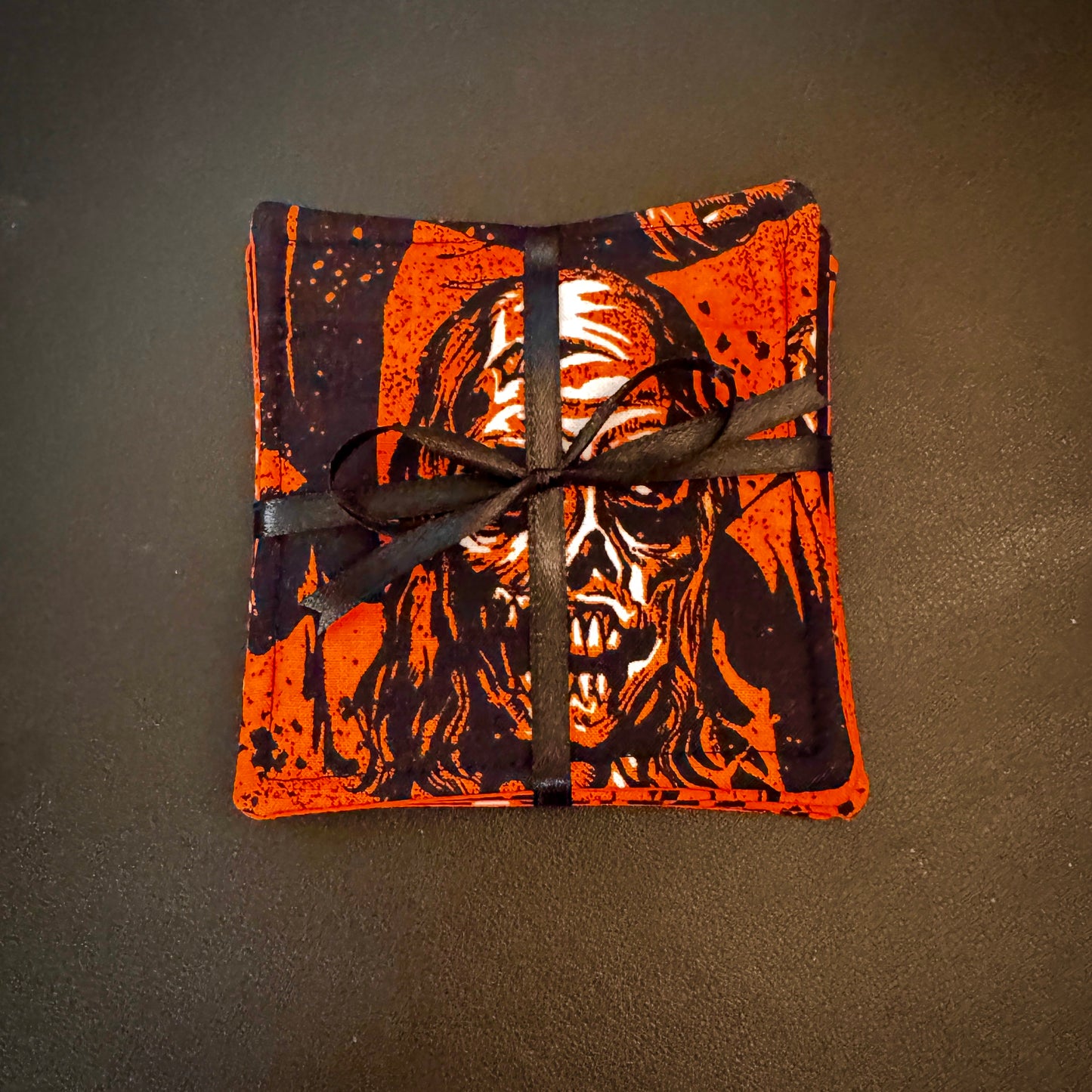 Summon the undead to your living space with this striking set of 4 handmade cotton coasters, inspired by classic B-movie horror and zombie comics. This set brings a bold, high-contrast alternative aesthetic to your surfaces.