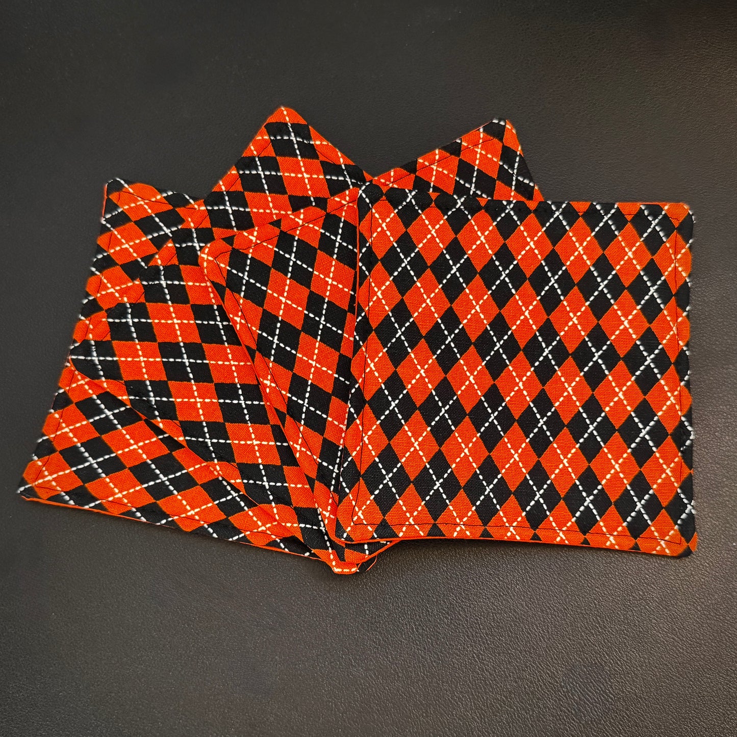 Bring a touch of retro mid-century charm and alternative flair to your tabletop with this set of 4 handmade cotton coasters. Featuring a striking, high-contrast geometric pattern, these coasters perfectly blend vintage pin-up glamour, rockabilly style, and a subtle nod to classic spooky aesthetics.