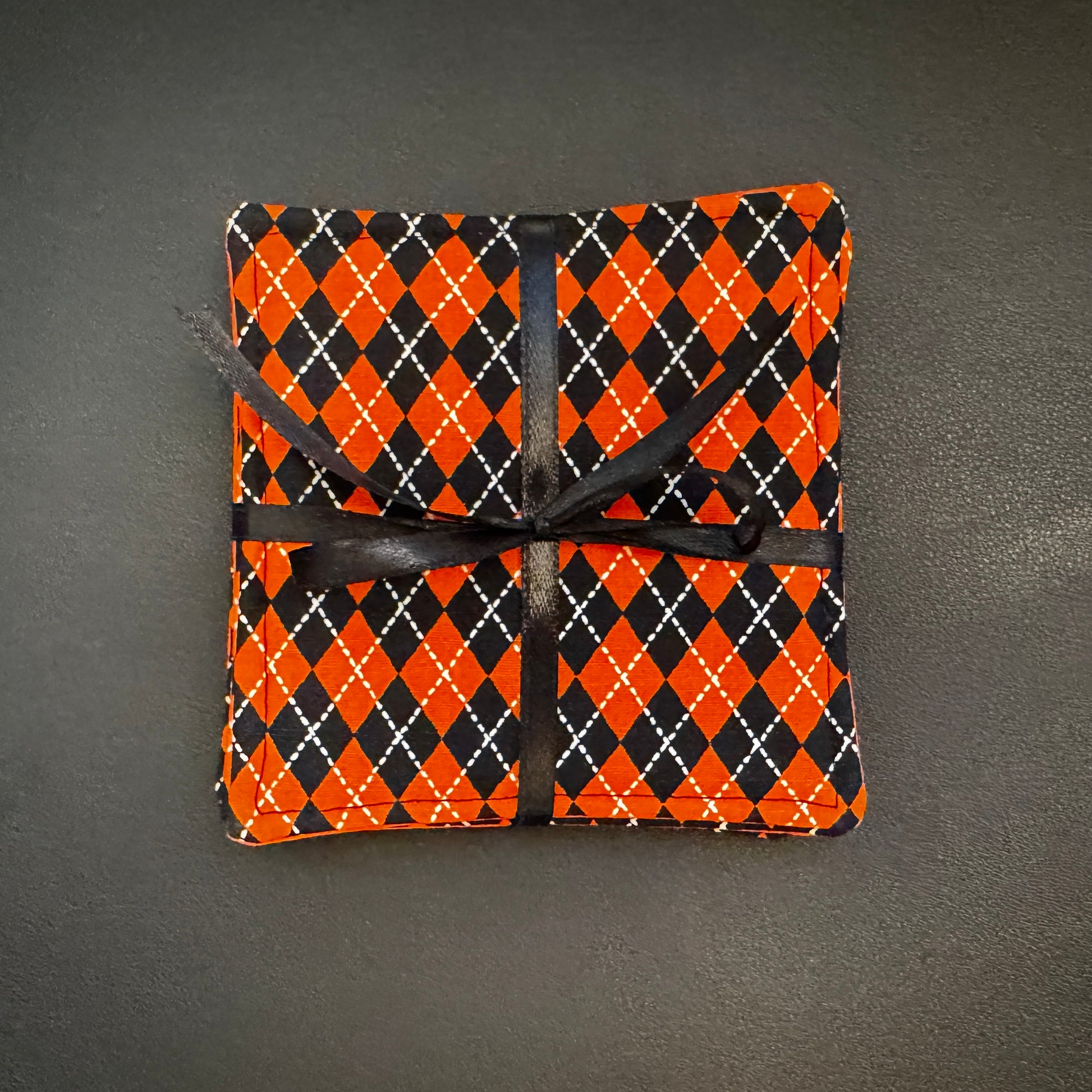 Bring a touch of retro mid-century charm and alternative flair to your tabletop with this set of 4 handmade cotton coasters. Featuring a striking, high-contrast geometric pattern, these coasters perfectly blend vintage pin-up glamour, rockabilly style, and a subtle nod to classic spooky aesthetics.