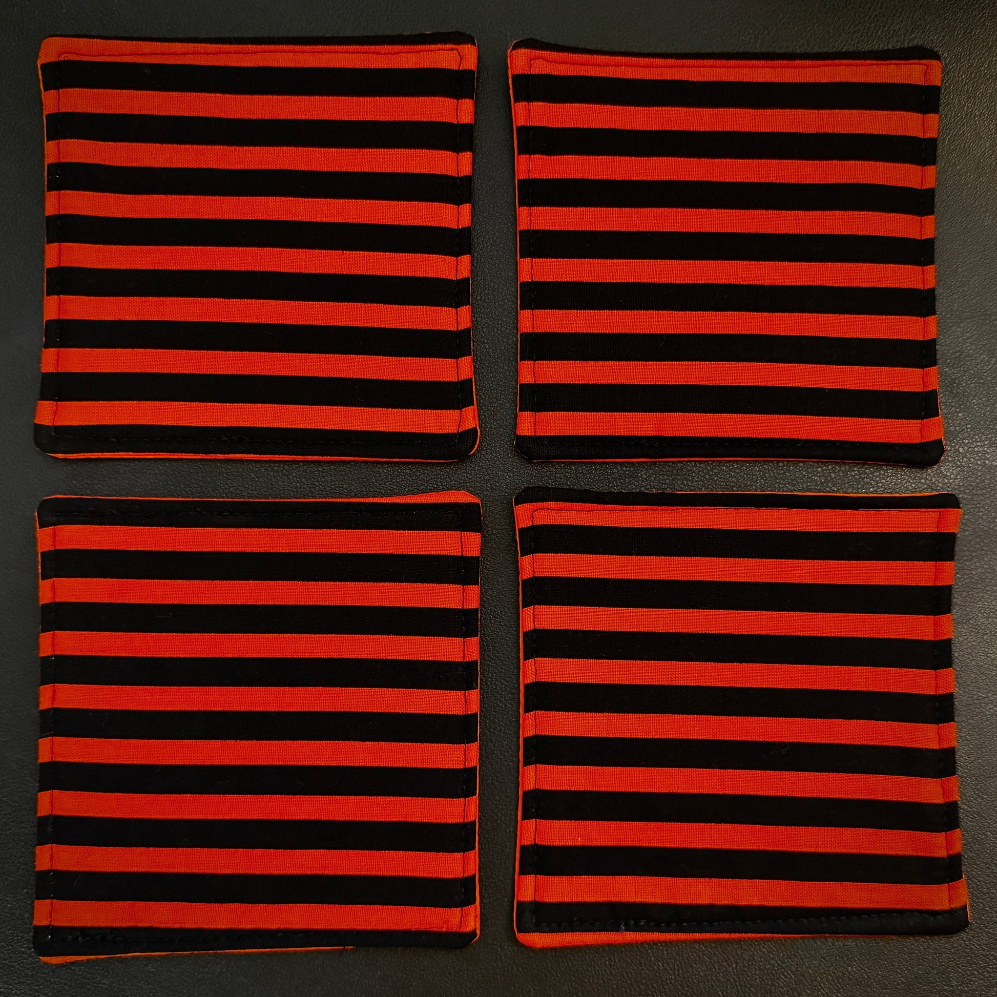 Embrace a classic, timeless pattern with a dark alternative twist with this matching set of 4 handmade cotton coasters. Featuring a striking, high-contrast linear design, these drink mats perfectly channel vintage punk rock, timeless goth culture, and a subtle nod to spooky cinematic aesthetics.