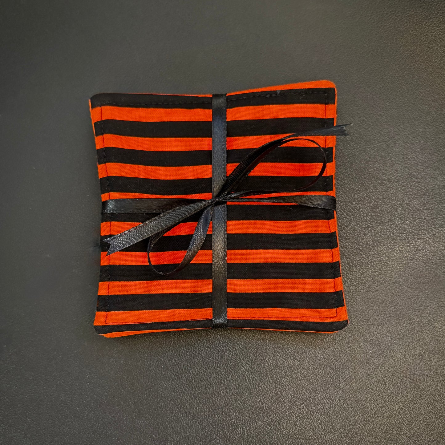 Embrace a classic, timeless pattern with a dark alternative twist with this matching set of 4 handmade cotton coasters. Featuring a striking, high-contrast linear design, these drink mats perfectly channel vintage punk rock, timeless goth culture, and a subtle nod to spooky cinematic aesthetics.