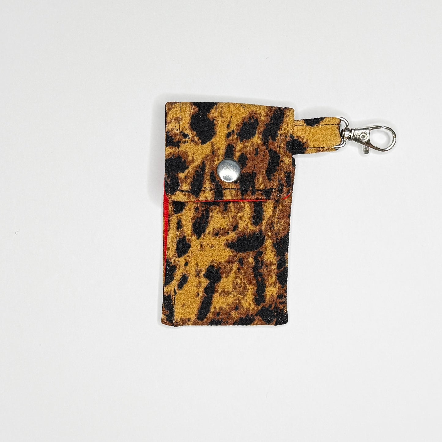 Keep your favorite lip color or balm secure and stylishly close at hand with this handmade fabric keychain pouch. Perfectly capturing a timeless rockabilly aesthetic and retro pin-up glamour, this compact accessory ensures you never lose your essentials at the bottom of your bag again.