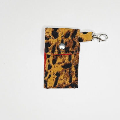 Keep your favorite lip color or balm secure and stylishly close at hand with this handmade fabric keychain pouch. Perfectly capturing a timeless rockabilly aesthetic and retro pin-up glamour, this compact accessory ensures you never lose your essentials at the bottom of your bag again.