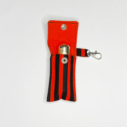 Keep your favorite lip color or balm secure and stylishly close at hand with this handmade fabric keychain pouch. Perfectly capturing a timeless rockabilly aesthetic, punk rock edge, and classic goth glamour, this compact accessory ensures you never lose your essentials at the bottom of your bag again.

This tailored fabric holder features a classic vertical stripe design in a high-contrast palette of vibrant orange and deep midnight black. Designed for ultimate everyday convenience, it includes a secure me