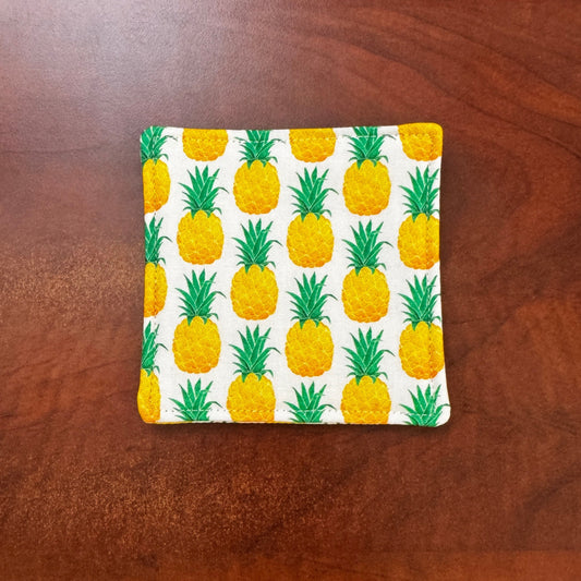 Keep your surfaces safe and stylish with our 100% cotton pineapple coaster. This charming coaster features a vibrant pineapple print that adds a touch of fresh, fruity fun to any room. Crafted with an absorbent cotton batting layer inside, it's designed to soak up condensation and protect your furniture from unsightly water rings and spills. Perfect for coffee mugs, glasses, or teacups, this durable and machine-washable coaster is a delightful addition to your kitchen or living room. Elevate your home decor