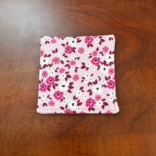 Elevate your space with this playful 100% cotton pink floral coaster. Featuring a vibrant and stylish floral print, this coaster brings a touch of floral and fun to your home. Crafted with an absorbent cotton batting layer inside, it's designed to soak up condensation and protect your furniture from unsightly water rings and spills. Perfect for coffee mugs, glasses, or teacups, this durable and machine-washable coaster is a delightful addition to your kitchen or living room. Elevate your home decor with thi