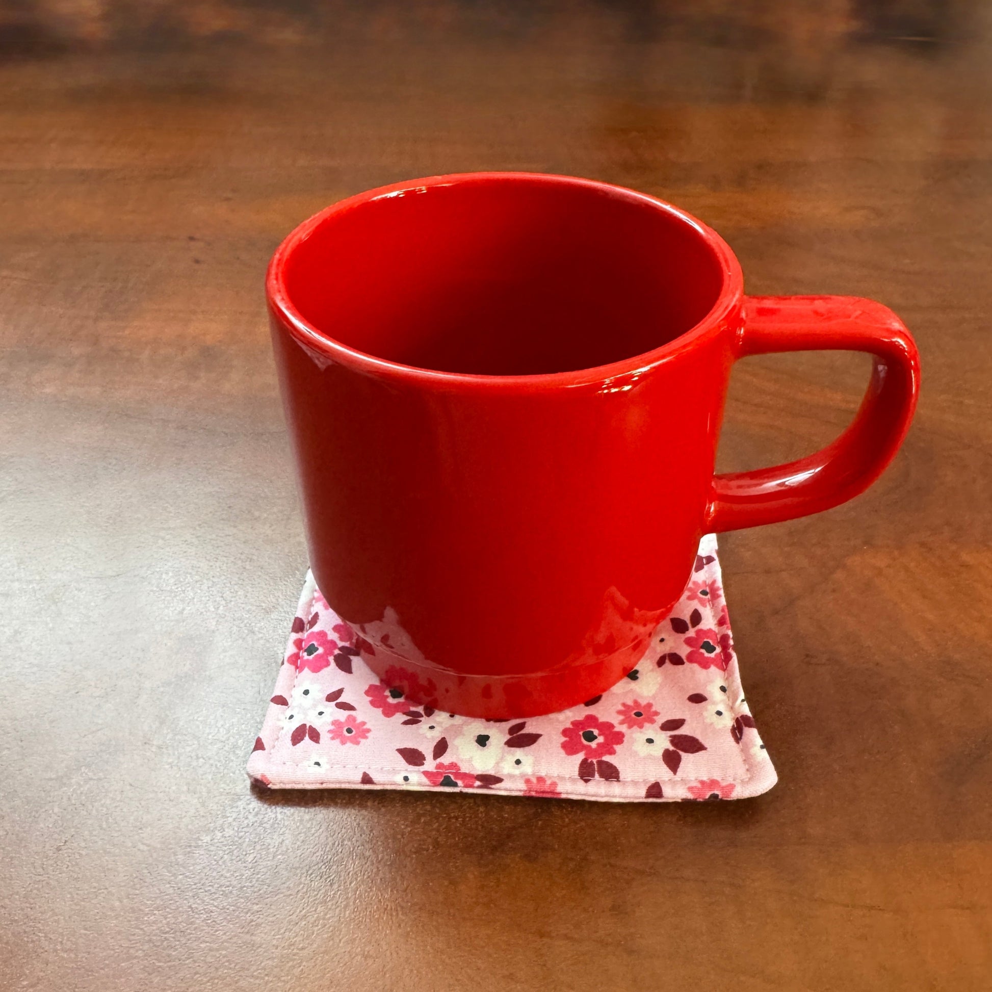 Elevate your space with this playful 100% cotton pink floral coaster. Featuring a vibrant and stylish floral print, this coaster brings a touch of floral and fun to your home. Crafted with an absorbent cotton batting layer inside, it's designed to soak up condensation and protect your furniture from unsightly water rings and spills. Perfect for coffee mugs, glasses, or teacups, this durable and machine-washable coaster is a delightful addition to your kitchen or living room. Elevate your home decor with thi