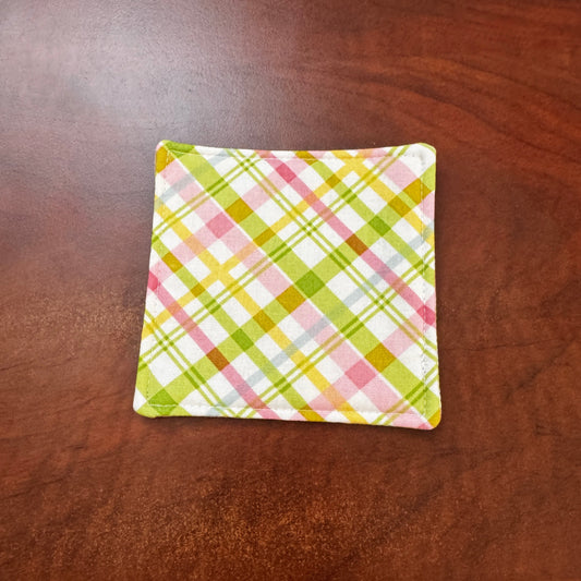Elevate your space with this playful 100% cotton pink and green plaid coaster. Featuring a vibrant and stylish pink and green plaid print, this coaster brings a touch of retro fun to your home. Crafted with an absorbent cotton batting layer inside, it's designed to soak up condensation and protect your furniture from unsightly water rings and spills. Perfect for coffee mugs, glasses, or teacups, this durable and machine-washable coaster is a delightful addition to your kitchen or living room. Elevate your h
