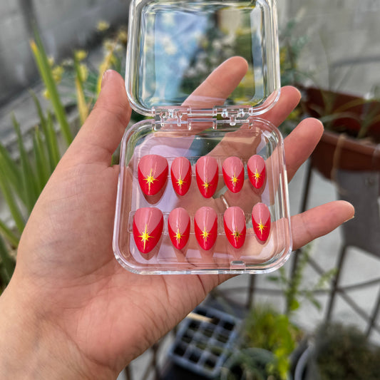 Get ready for "Red Retro Starburst" with these stunning, retro starburst design press-on nails. Featuring a pink base, red french tip design, and gold starbursts with a glossy finish. Each set is a miniature work of art, meticulously designed and hand-painted, adding a unique flair to any occasion. No time for salon appointments? Say hello to instant glamour that’s ready whenever you are. Our durable, high-quality press-ons offer a flawless, comfortable fit and are designed to last.