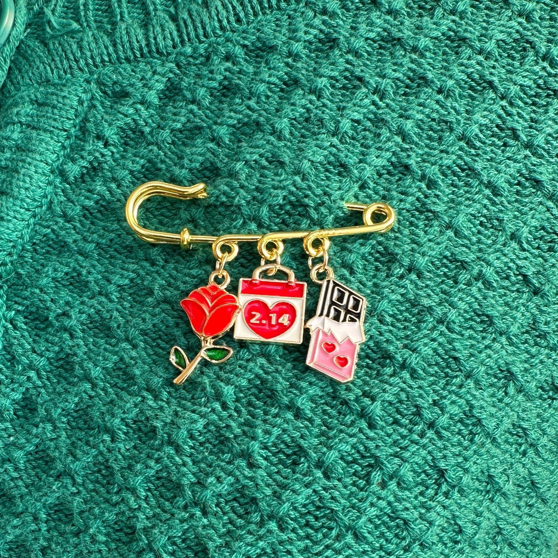 Elevate your Valentine's Day with this adorable gold iron pin brooch featuring rose and chocolate enamel charms. Perfect for adding a touch of love to any outfit.