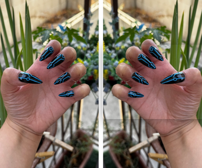 Get ready for "The Grid" and step into the future with custom, hand-painted press-on nails inspired by high-tech cyber circuitry and sci-fi aesthetic. Featuring slick, high-gloss black bases layered with ultra-crisp circuit linework, "The Grid" charges up under UV or sunlight to emit a vivid, electric glow when the lights go down. Available in both blue and red glow finishes!