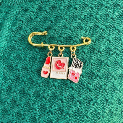 Elevate your Valentines Day with this adorable gold iron pin brooch featuring drink and heart enamel charms. Perfect for adding a touch of love to any outfit.