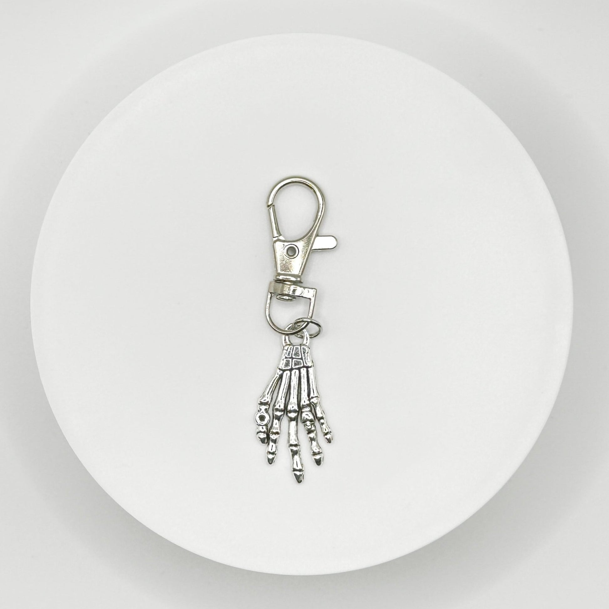 Grasp your style with our spooky skeleton hand charm! This unique, durable, and versatile accessory is perfect for horror fans and dark style lovers. Attach it to your bag, purse, or backpack for a touch of the macabre.