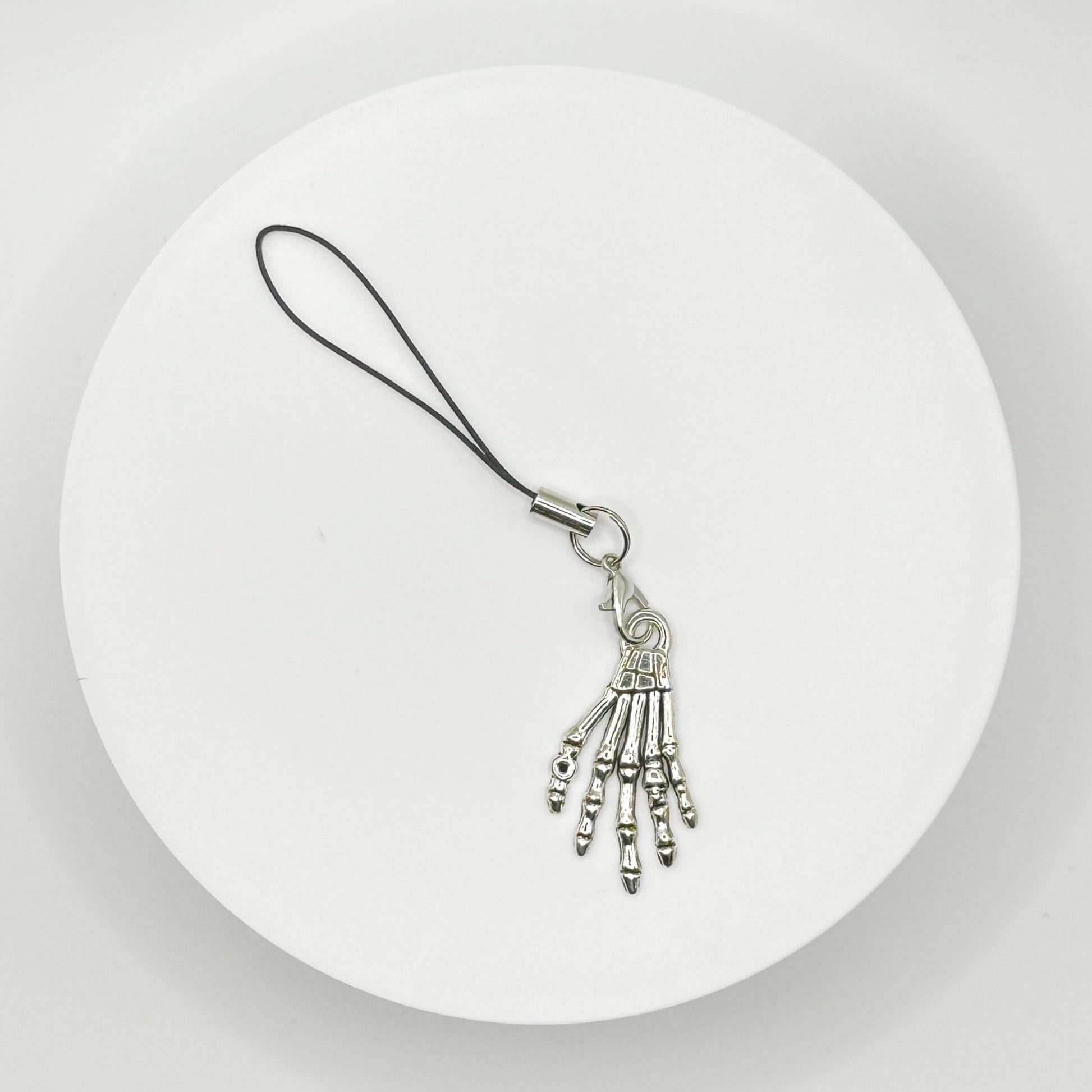 Grasp your style with our spooky skeleton hand charm! This unique, durable, and versatile accessory is perfect for horror fans and dark style lovers. Attach it to your bag, purse, or backpack for a touch of the macabre.