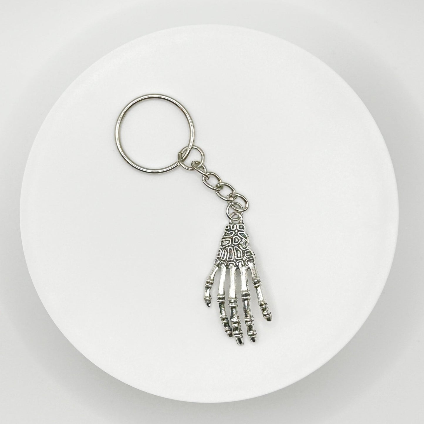 Grasp your style with our spooky skeleton hand charm! This unique, durable, and versatile accessory is perfect for horror fans and dark style lovers. Attach it to your bag, purse, or backpack for a touch of the macabre.