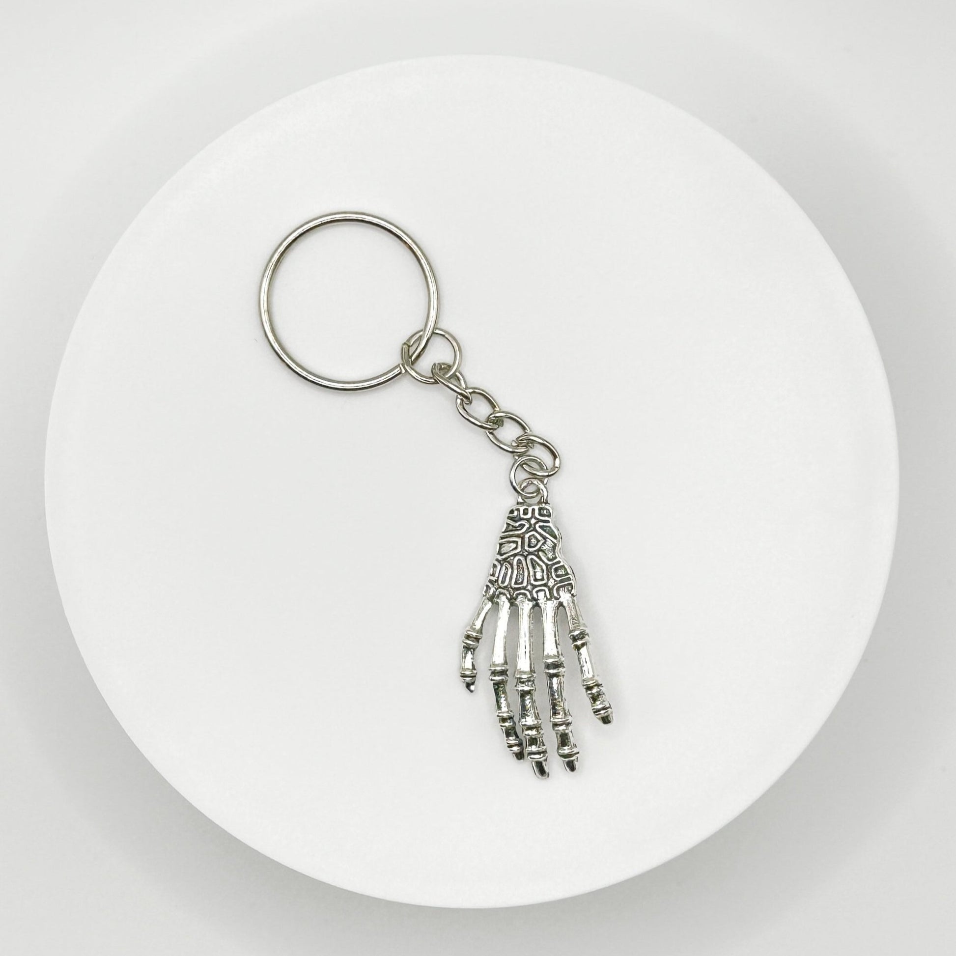 Grasp your style with our spooky skeleton hand charm! This unique, durable, and versatile accessory is perfect for horror fans and dark style lovers. Attach it to your bag, purse, or backpack for a touch of the macabre.