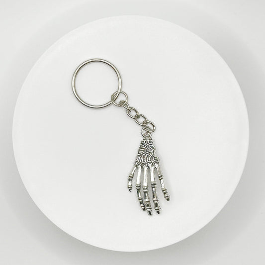 Grasp your style with our spooky skeleton hand charm! This unique, durable, and versatile accessory is perfect for horror fans and dark style lovers. Attach it to your bag, purse, or backpack for a touch of the macabre.