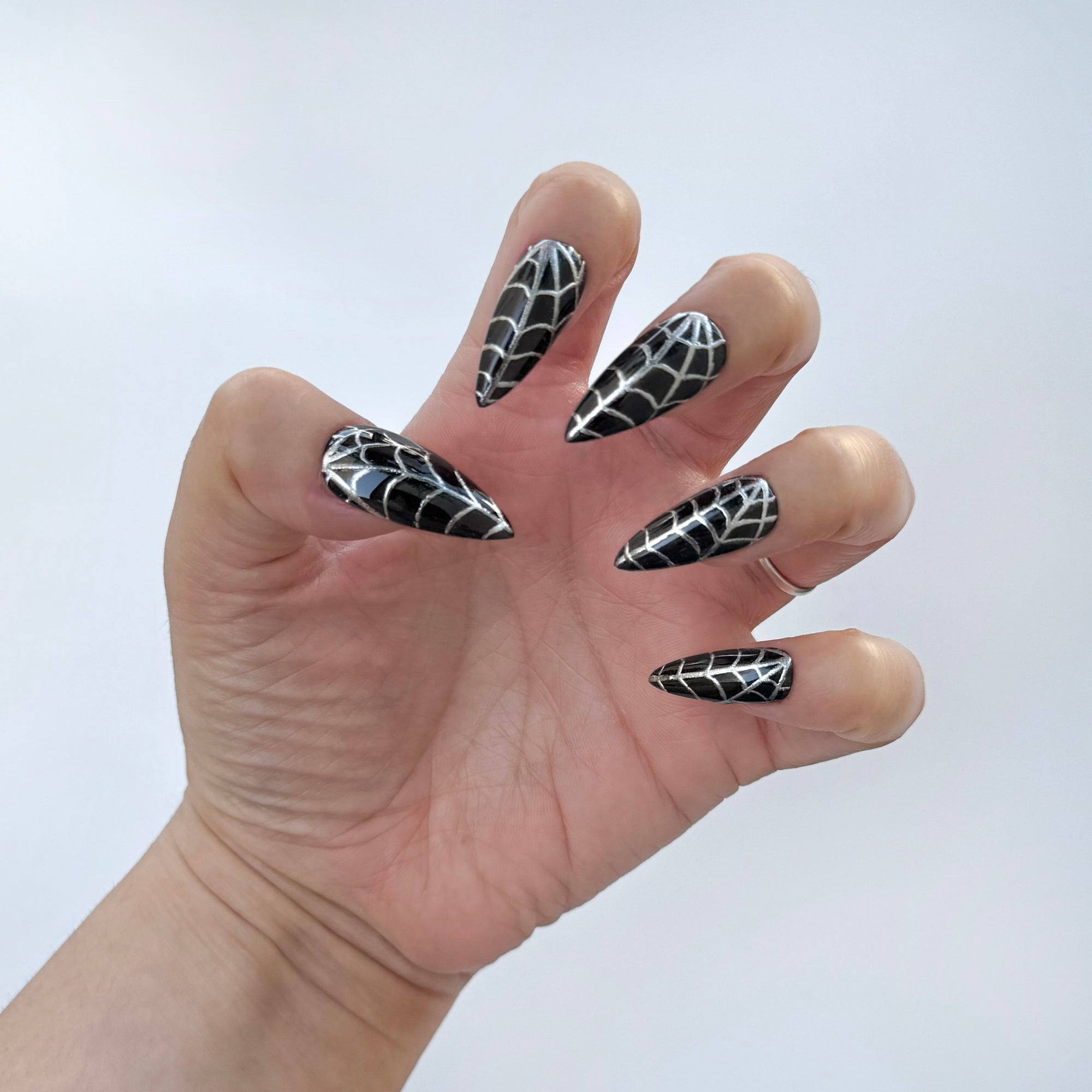 Get ready for "The Silver Weaver" with these stunning, black and silver press-on nails. Featuring a black base and silver web design. Each set is a miniature work of art, meticulously designed and hand-painted, adding a unique flair to any occasion. No time for salon appointments? Say hello to instant glamour that’s ready whenever you are. Our durable, high-quality press-ons offer a flawless, comfortable fit and are designed to last.